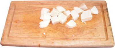 mozzarella pokrojona w kostk, drewniana deska do krojenia